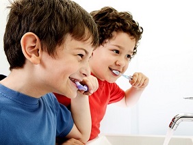 Two little boys brushing their teeth.