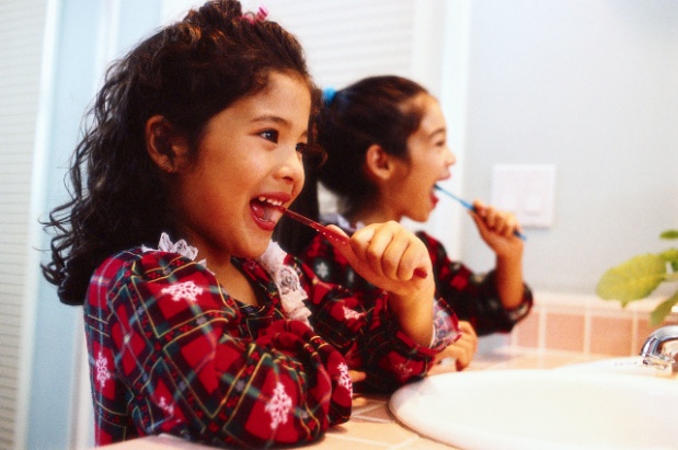 Two little girls brushing their teeth.